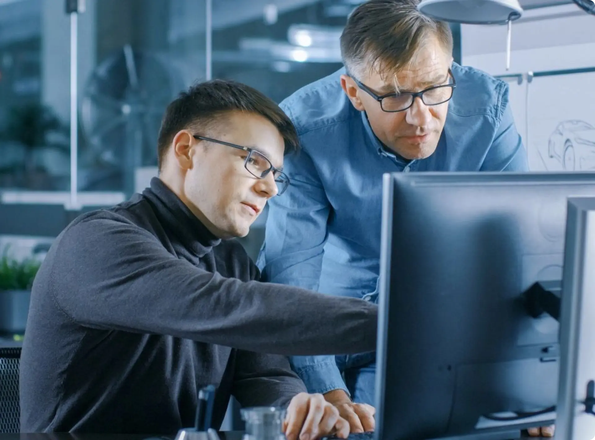 Two men looking at a computer screen.